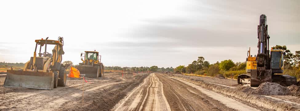Bulldozers and excavators preparing and grading dirt base for road construction Bulldozers and excavators preparing and grading dirt base for road construction
