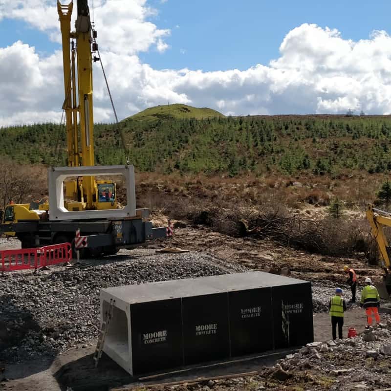 Mobile crane lowering precast concrete box culvert section during drainage infrastructure construction Mobile crane lowering precast concrete box culvert section during drainage infrastructure construction