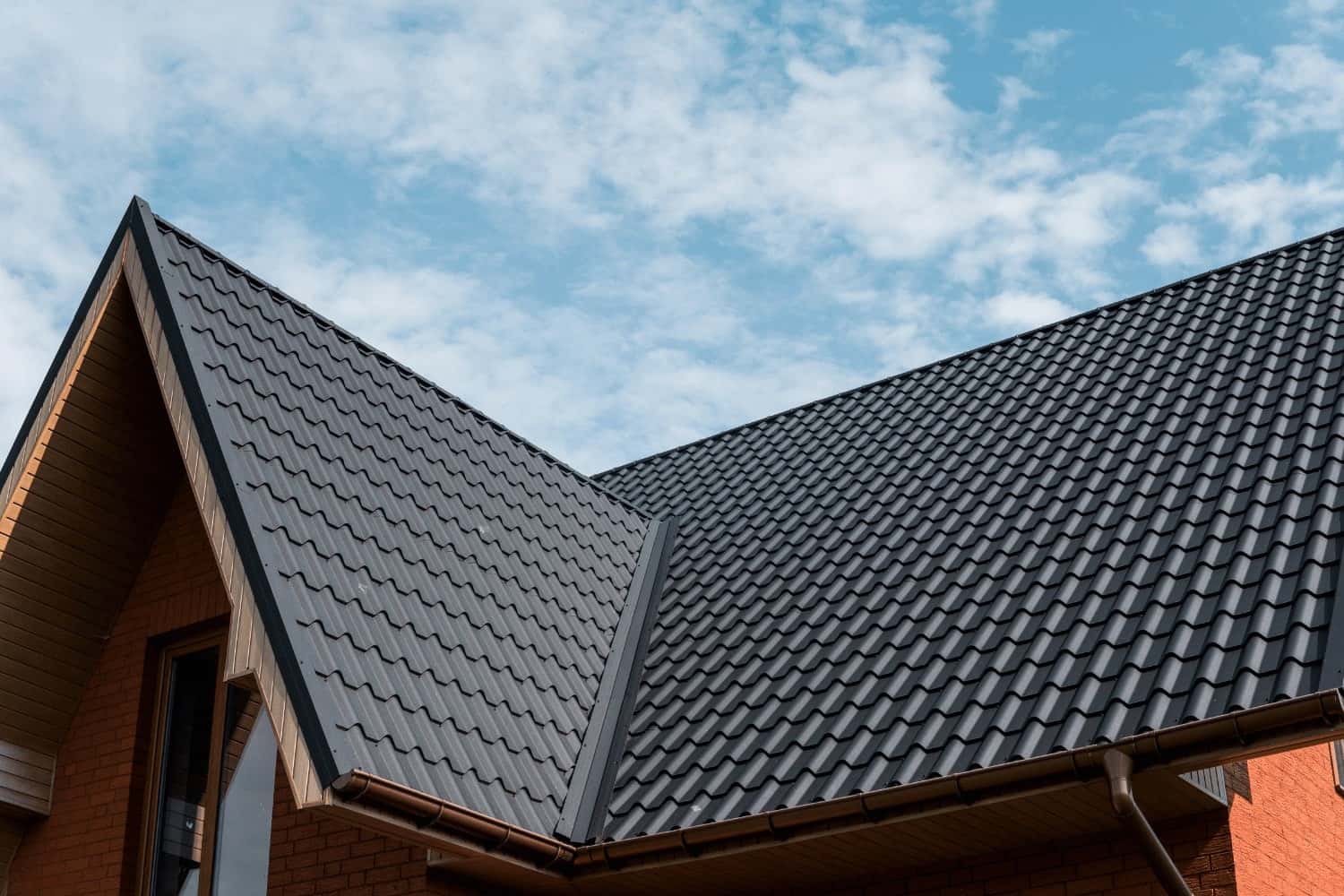 Modern residential home featuring dark grey wave-profile metal tile roofing Modern residential home featuring dark grey wave-profile metal tile roofing