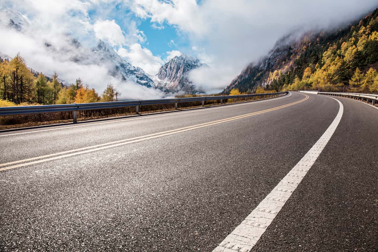 Completed mountain road paving project showing durable asphalt surfacing and guardrail installation Completed mountain road paving project showing durable asphalt surfacing and guardrail installation